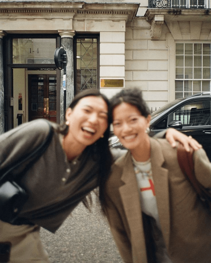 Two friends laughing together on a city street